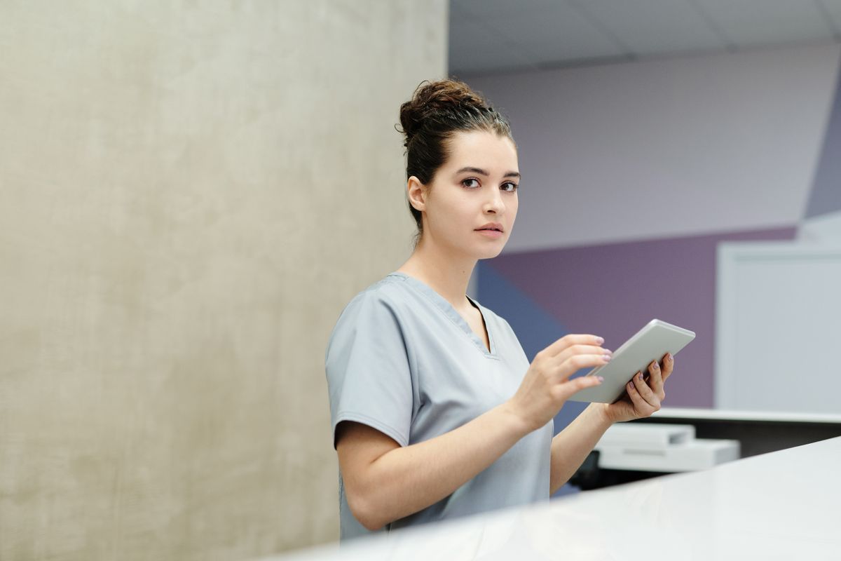 A receptionist using a tablet at a modern salon desk